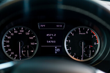 Fototapeta premium Close-up of the odometer and dashboard of a luxury car with a black interior after detailing and washing at a car service