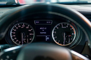 Close-up of the odometer and dashboard of a luxury car with a black interior after detailing and...