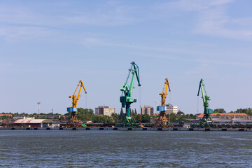 Many harbor cranes on the jetty. Bulk material handling. Photo taken from on a sunny day.