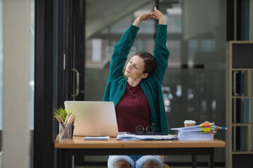 Beautiful businesswoman stretching hands in office.