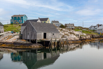 Fototapeta na wymiar Weathered boathouse with dock in a small village on a cove on the shores of the Atlantic ocean.