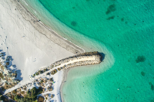 An aerial view of a groin leading out into water