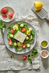 Salad with feta, mint, melon, strawberries, lemon and green peas. Fresh summer salad. Vegetarian salad