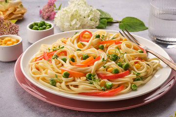 Fresh Italian pasta with green peas, bell peppers and corn. Close-up. Italian Cuisine