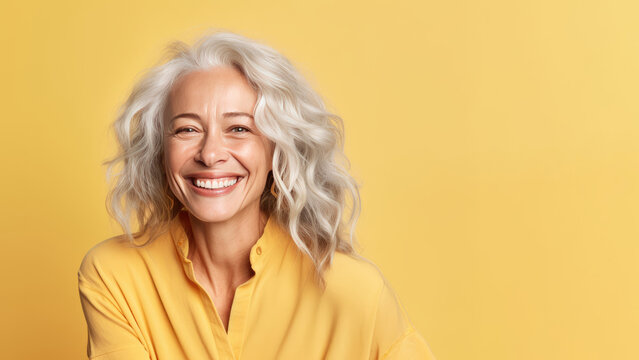 Smiling attractive woman 50s years old look to the camera, isolated on plain yellow background studio portrait. People lifestyle concept. AI Generated.