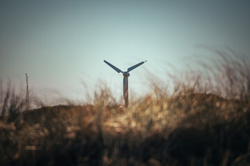Wind Turbine spinning in a grassy field