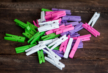 wooden clothespins, multicolored on a wooden background