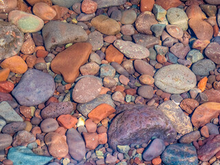 Closeup of colorful rocks in clear water on the edge of Lake Superior on the Upper Peninsula of...