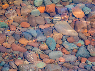 Closeup of colorful rocks in clear water on the edge of Lake Superior on the Upper Peninsula of Michigan USA