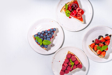 

Summer cafe baking menu background, sweet cheesecake portion slices with various toppings, jam and berry fruits - strawberry, blueberry, raspberry, cherry 