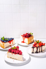 

Summer cafe baking menu background, sweet cheesecake portion slices with various toppings, jam and berry fruits - strawberry, blueberry, raspberry, cherry 