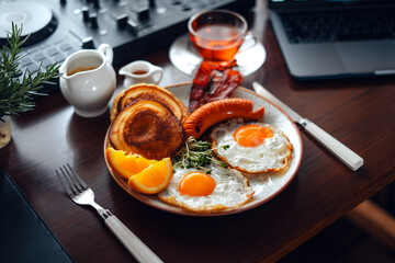 Breakfast pancakes, fried eggs, bacon, sausage and coffee.