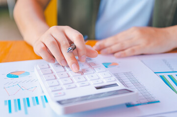 business person sitting at a desk at an office By using the calculator to work. Business Concept Analysis and Planning