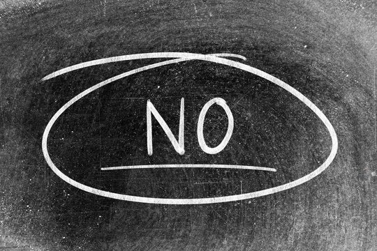 White chalk hand writing in word no and circle shape on blackboard background