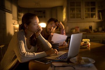 Worried young couple going over their home finances and bills late at night