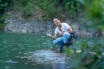 a young woman runs by the lake shore and plays with water