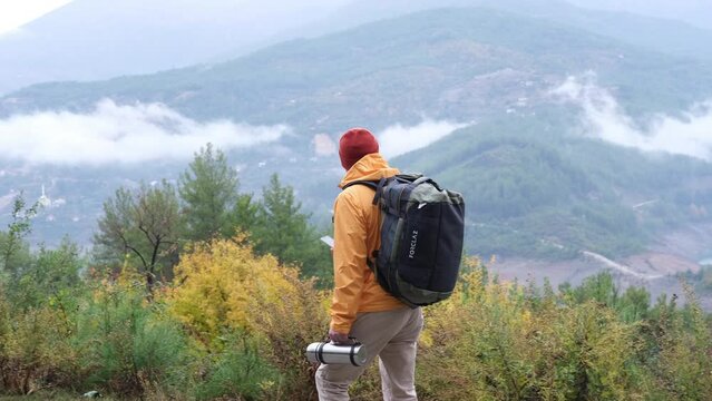 Nature trek hike man tourist taking pictures with phone at view of mountain landscape. Handsome male hipster walks in the autumn nature. Cool weather.