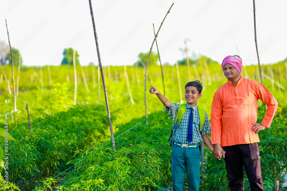 Wall mural Indian farmer with his son at agriculture field,  Father and son are standing in farm, They are happy because of successful sowing and enjoying sunset