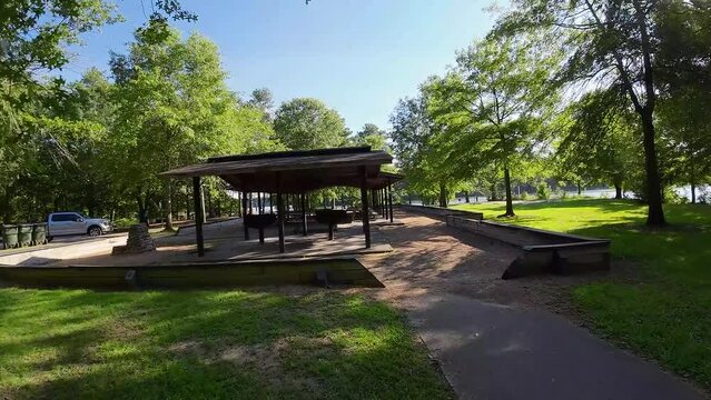 aerial FPV footage of a gorgeous summer landscape at Proctor Landing park with a lake, lush green trees, grass and plants with blue sky and clouds at Lake Acworth in Acworth Georgia USA