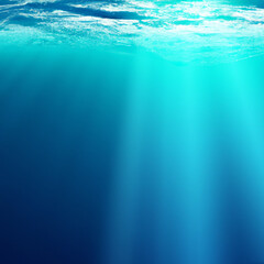 Beautiful blue ocean surface seen from underwater with rays of sunlight shining through. Abstract Fractal waves underwater