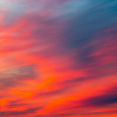 Vibrant orange red colours of sunset sky with clouds. Dramatic sky, light majestic sunset
