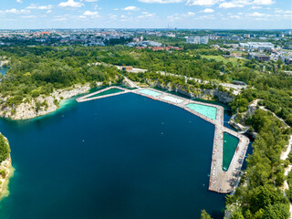 Zakrzówek, Krakow, Poland. Swimming and paddling pools, sunbathing platforms on Zakrzowek lake with steep cliffs in place of former flooded limestone quarry. New public recreational place. Aerial view - 624823699
