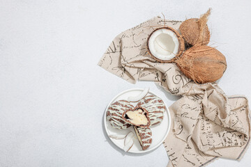 Profiteroles choux pastry buns with coconut cream served in tropical style. Palm leaves