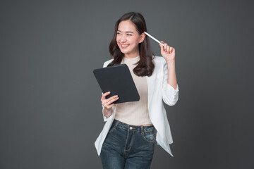 Young asian woman confident manager worker use modern technology digital tablet work remote distance isolated grey color background. Beautiful woman using smartphone. Lifestyle concept.	