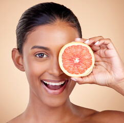 Happy woman, portrait and grapefruit, natural beauty and vitamin c with sustainable skincare on studio background. Face, female model and citrus fruit, eco friendly dermatology and cosmetic care