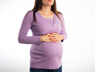 Pregnant girl holding her stomach during pregnancy on a white background. The concept of discomfort...