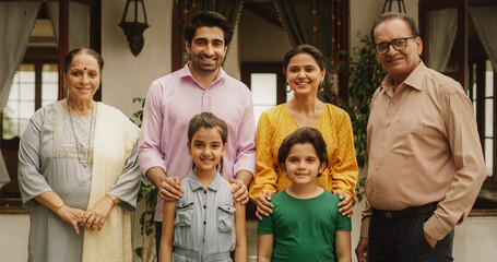 Portrait of Happy Indian Family Posing Together in Beautifully Authentic Mumbai House. Gorgeous Parents, Grandparents, and Cute Two Kids Looking at the Camera, Happily Taking a Family Photo