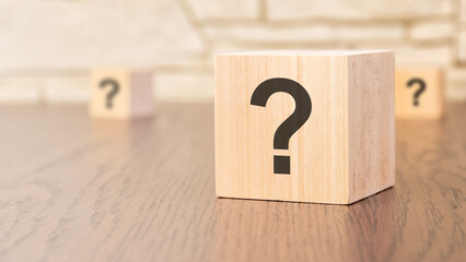 wooden blocks with question sign on wooden table, close up. space for text
