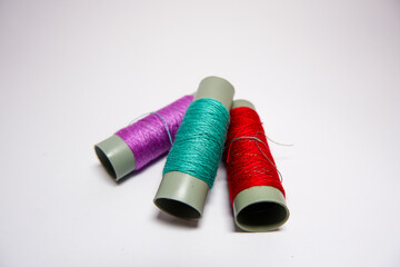 Sewing threads of different colors on white background. Isolate, free space, close-up. 