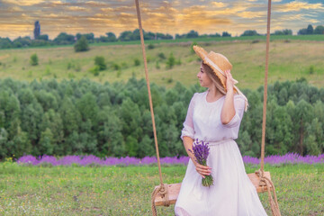 girl on a swing in a field of lavender. Selective focus