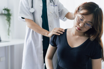 Doctor diagnosing female patient neck and shoulder pain.