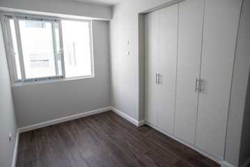 habitacion con closet y acabados de madera en el piso