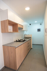 kitchenette de departamento con acabados de madera y muebles altos