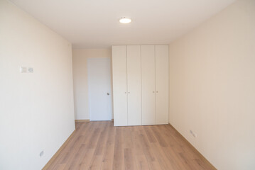 habitacion con close y baño de departamento con acabados de madera y color blanco