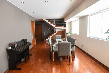 comedor de departamento duplex con piano y acabados de madera 