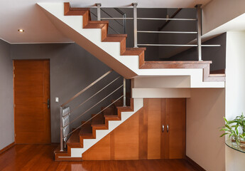 escaleras de departamento duplex con acabados de madera y barandas de metal