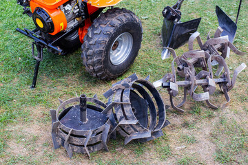 Obraz premium A set of attachments, hiller, milling cutters and lugs. Motoblock for agricultural work. Purchase and running-in of a motor cultivator.