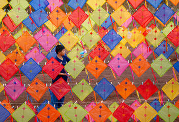 Fototapeta na wymiar Asian boy enjoy to play bubble gun alone in area of row of kites outdoor and day light.