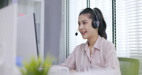 female call center worker is consulting with a customer who calls in for information over the phone in the office. Businessman wearing headphones to talk to customers. communication technology