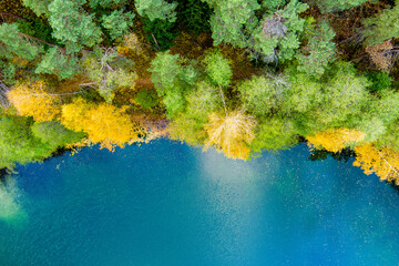 Fototapeta na wymiar Aerial view of beautiful green waters of lake Gela. Birds eye view of scenic emerald lake surrounded by pine forests. Clouds reflecting in Gela lake, near Vilnius, Lithuania.