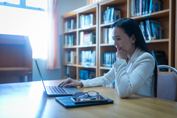A university lecturer gives an online lecture to students in office