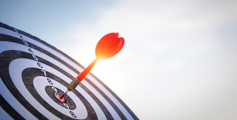 Close up shot red darts arrows in the target  of dartboard center on dark blue sky background....
