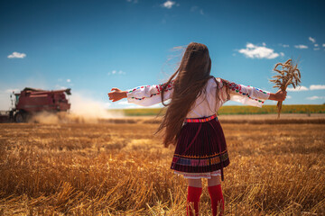 Harvest time of golden wheat field and slavic girl in  ethnic folklore costume with Bulgarian...