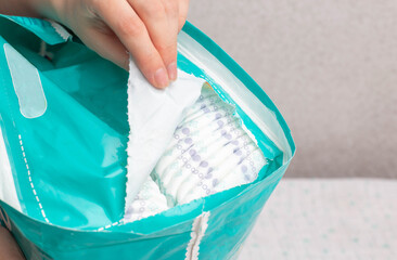Unpacking a whole package of baby diapers on a white background. Copy space for text