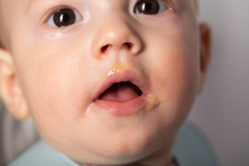 Portrait of a 9 month old baby with a dirty mouth after eating. The concept of feeding babies after breast milk. Close-up