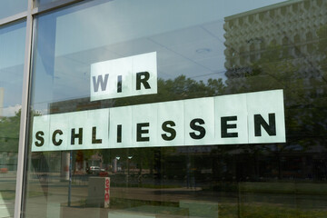 Schild mit der Aufschrift wir schließen am Schaufenster eines Geschäfts in Magdeburg - 624851035